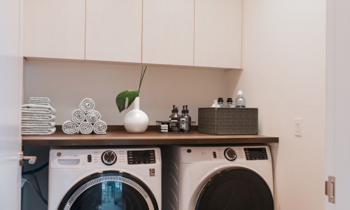 Walk-in laundry room with full-size front loading washer & dryer includes plenty of storage and counter space Cover Image